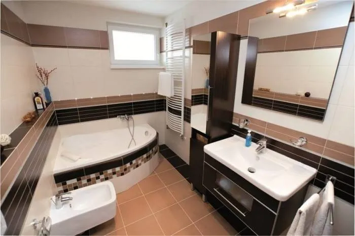 В небольшой ванной комнате сочетание чёрного цвета и бежевых оттенков выглядит смело и современно.
