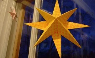 Объемная звезда из бумаги украшает окно к Новому году